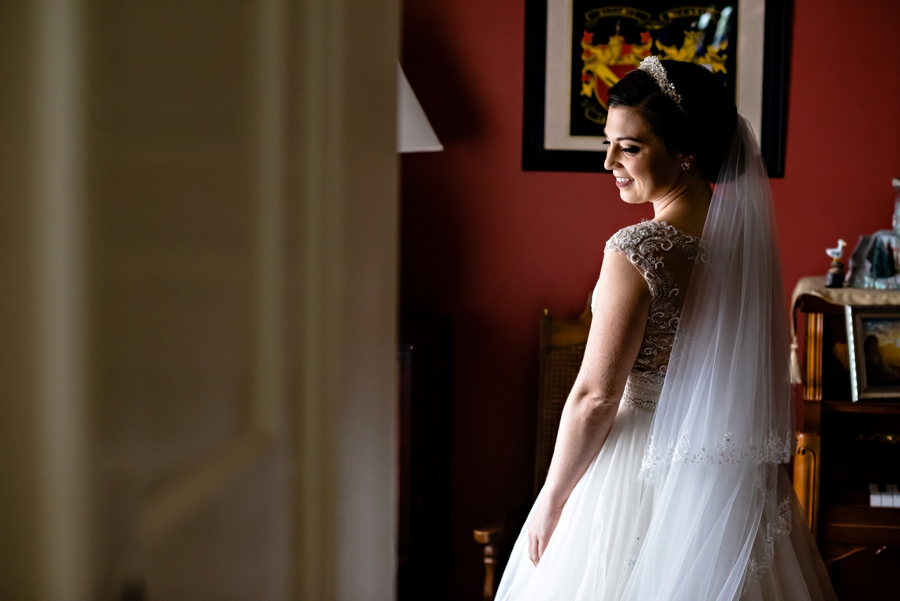 A bride smiles in her parents house before the ceremony.